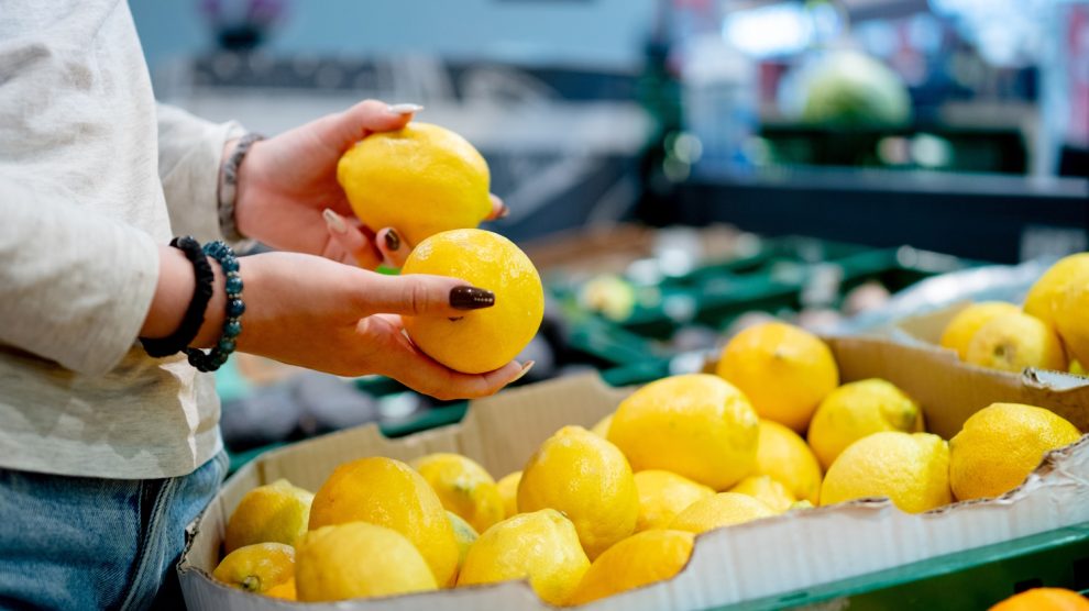 nő citromot válogat a boltban