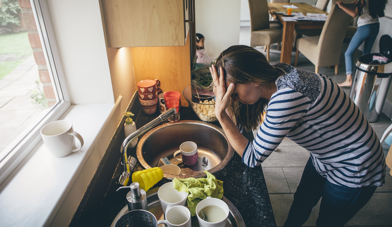 eldugult mosogató fölött szomorkodik egy nő
