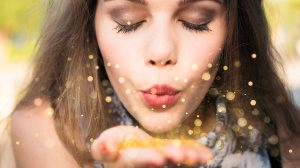 Arany konfettit fújó nő