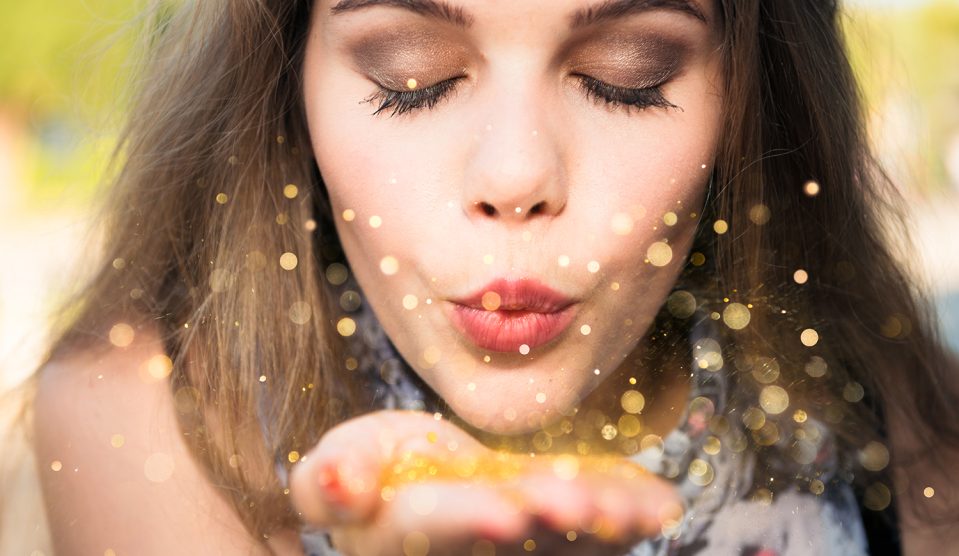 Arany konfettit fújó nő