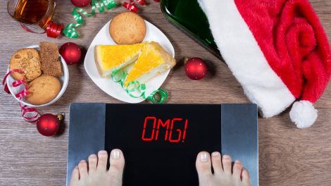 mérlegen álló ember, sütivel, karácsonyi desszertekkel