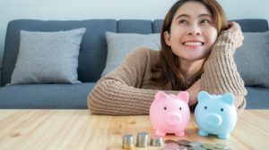 Egy lány mosolyog két persely felett