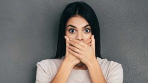 nő szája elé teszi a kezét