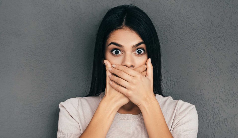 nő szája elé teszi a kezét