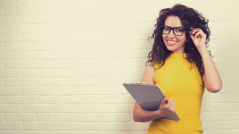 sárga ruhás nő áll a fal előtt