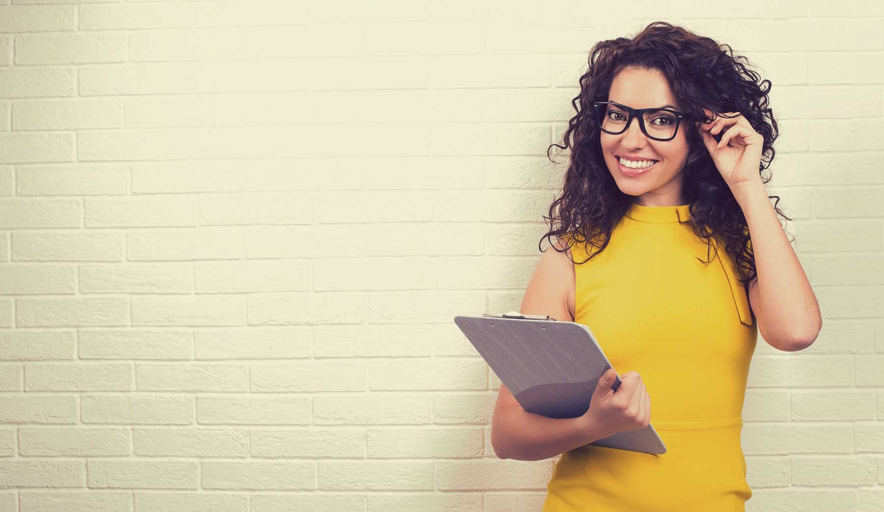 sárga ruhás nő áll a fal előtt