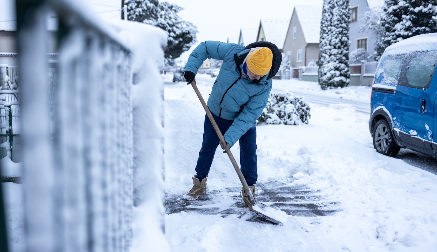 Egy férfi havat lapátol