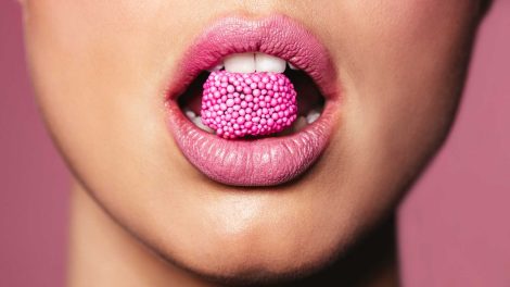 nő rúzsozott szájában cukor