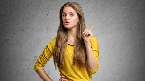 nő szürke háttér előtt figyelmeztet