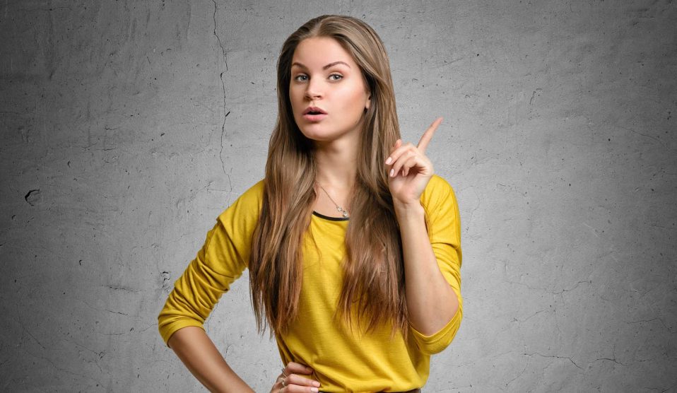 nő szürke háttér előtt figyelmeztet