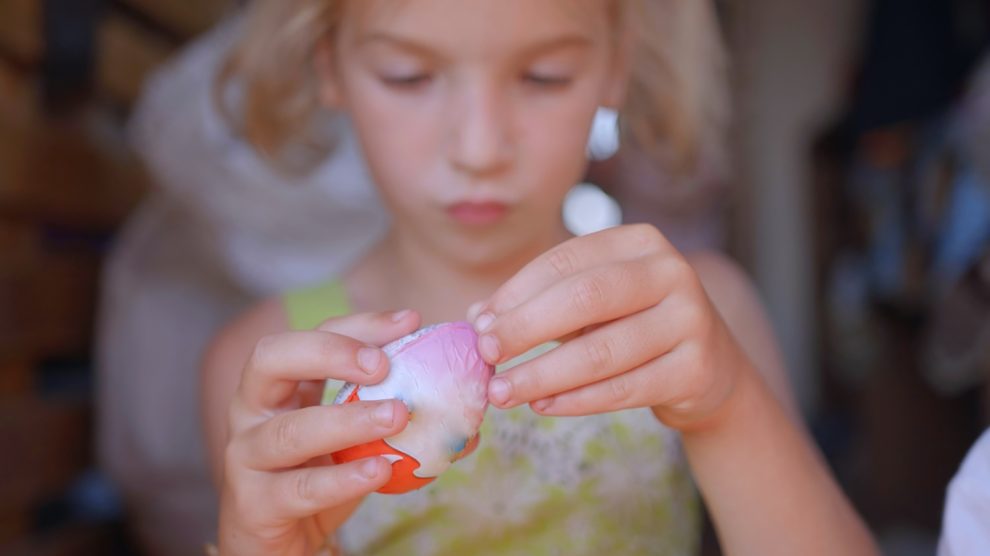 kinder tojást bont fel egy kislány