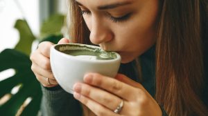 zöld matcha latte teát ivó fiatal lány