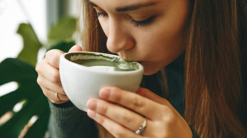 zöld matcha latte teát ivó fiatal lány