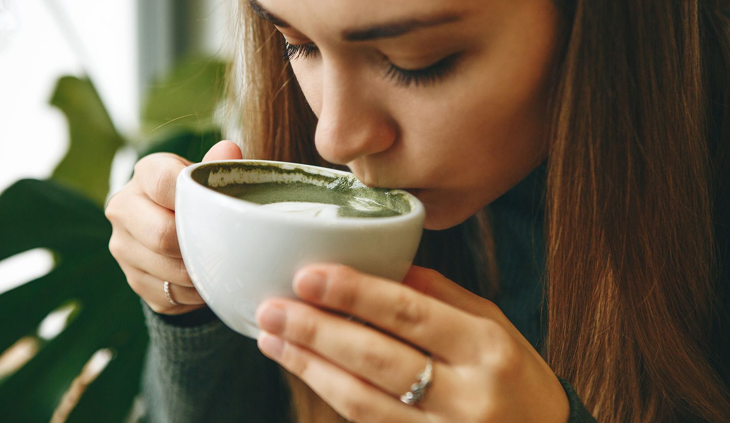 zöld matcha latte teát ivó fiatal lány