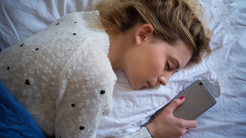 nő elaludt telefonnal a kezében