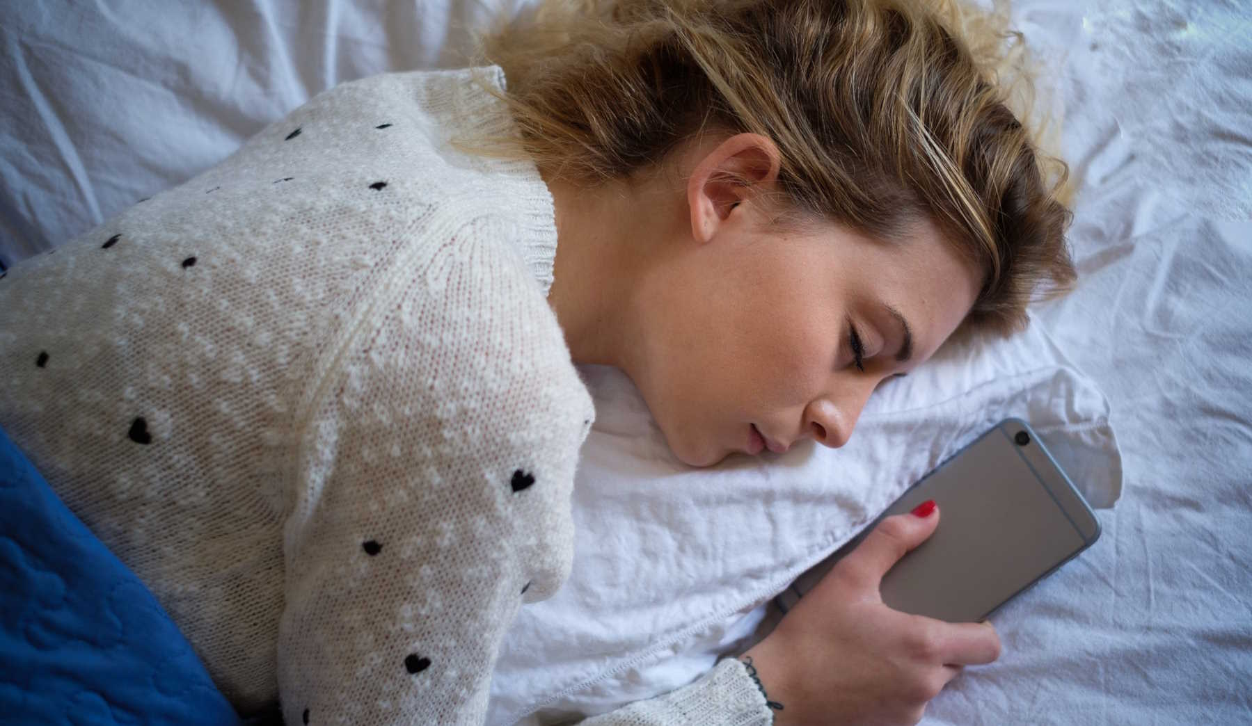 nő elaludt telefonnal a kezében