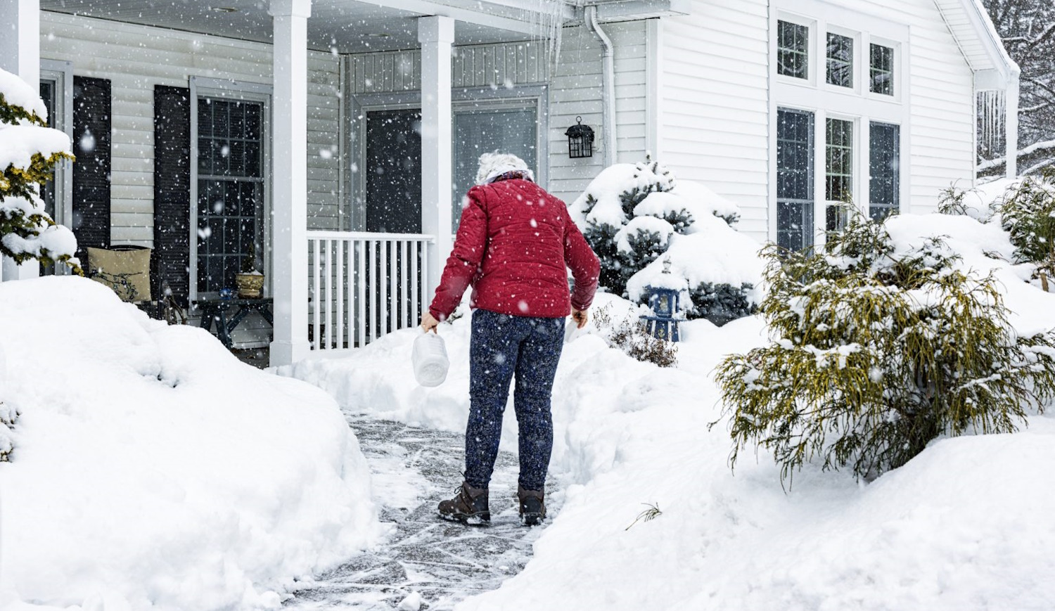 nő csúszkál havas időben a kocsibehajtón