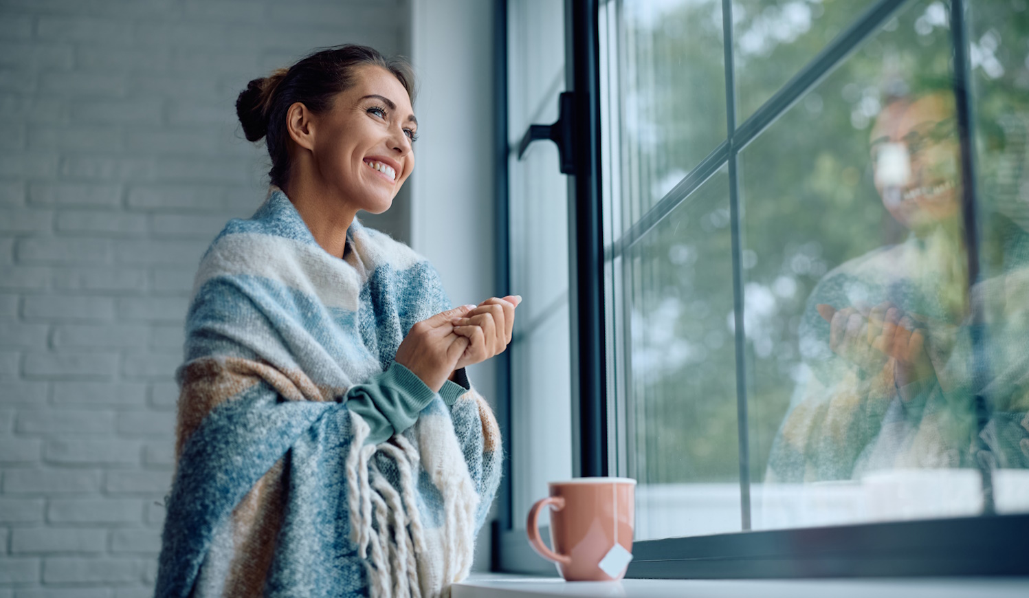 nő áll az ablakban a jó meleg szobában