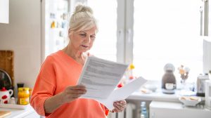 Nyugdíjas nő hivatalos iratot olvas