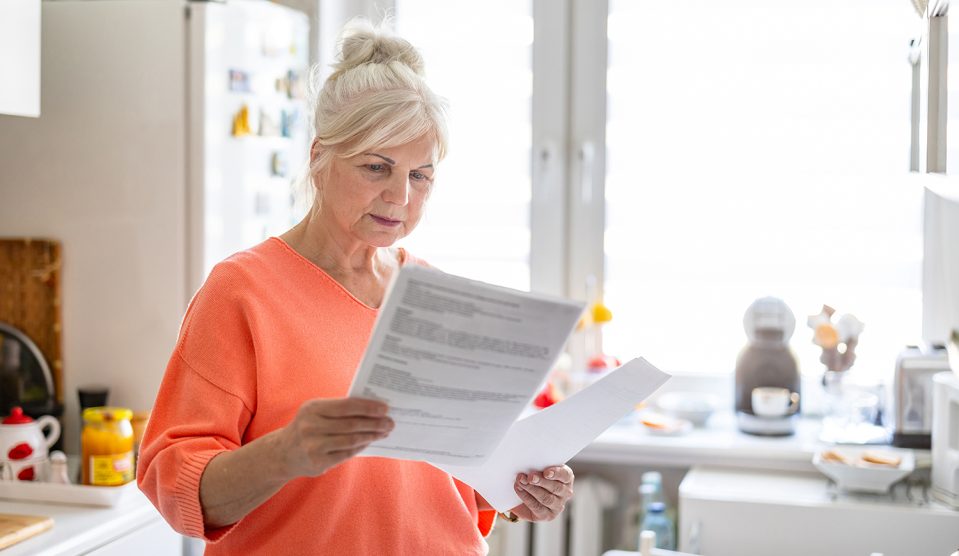 Nyugdíjas nő hivatalos iratot olvas