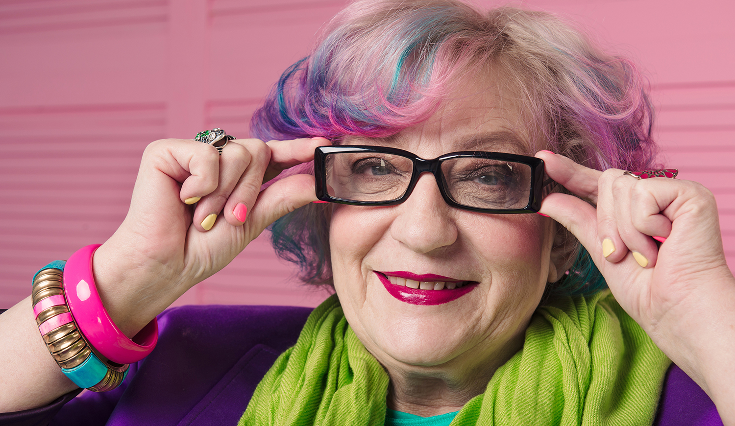 Színes hajú idős nő szemüvegben