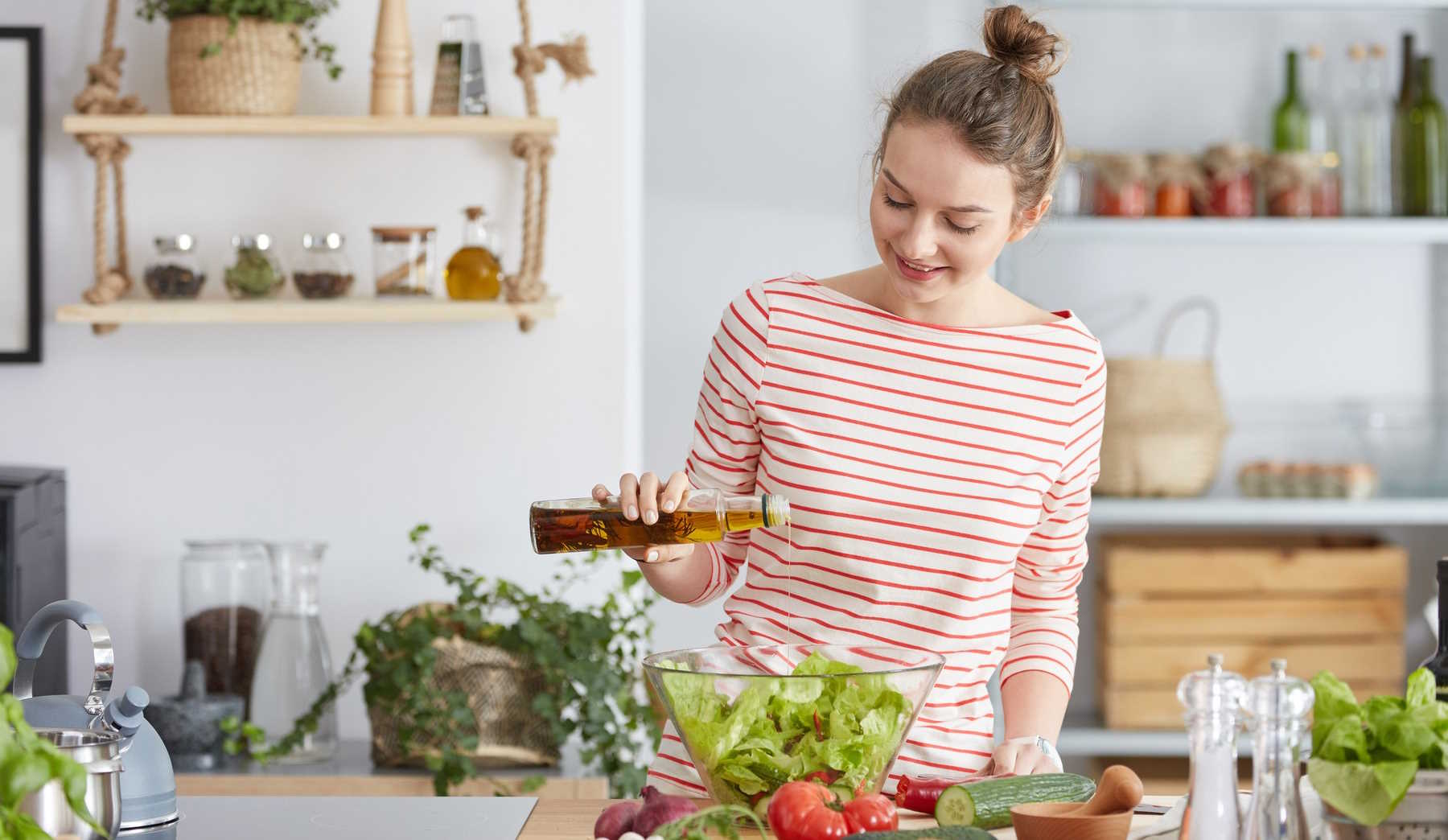 nő salátát készít a konyhában