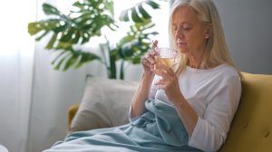 Egy nő iszik a kanapén