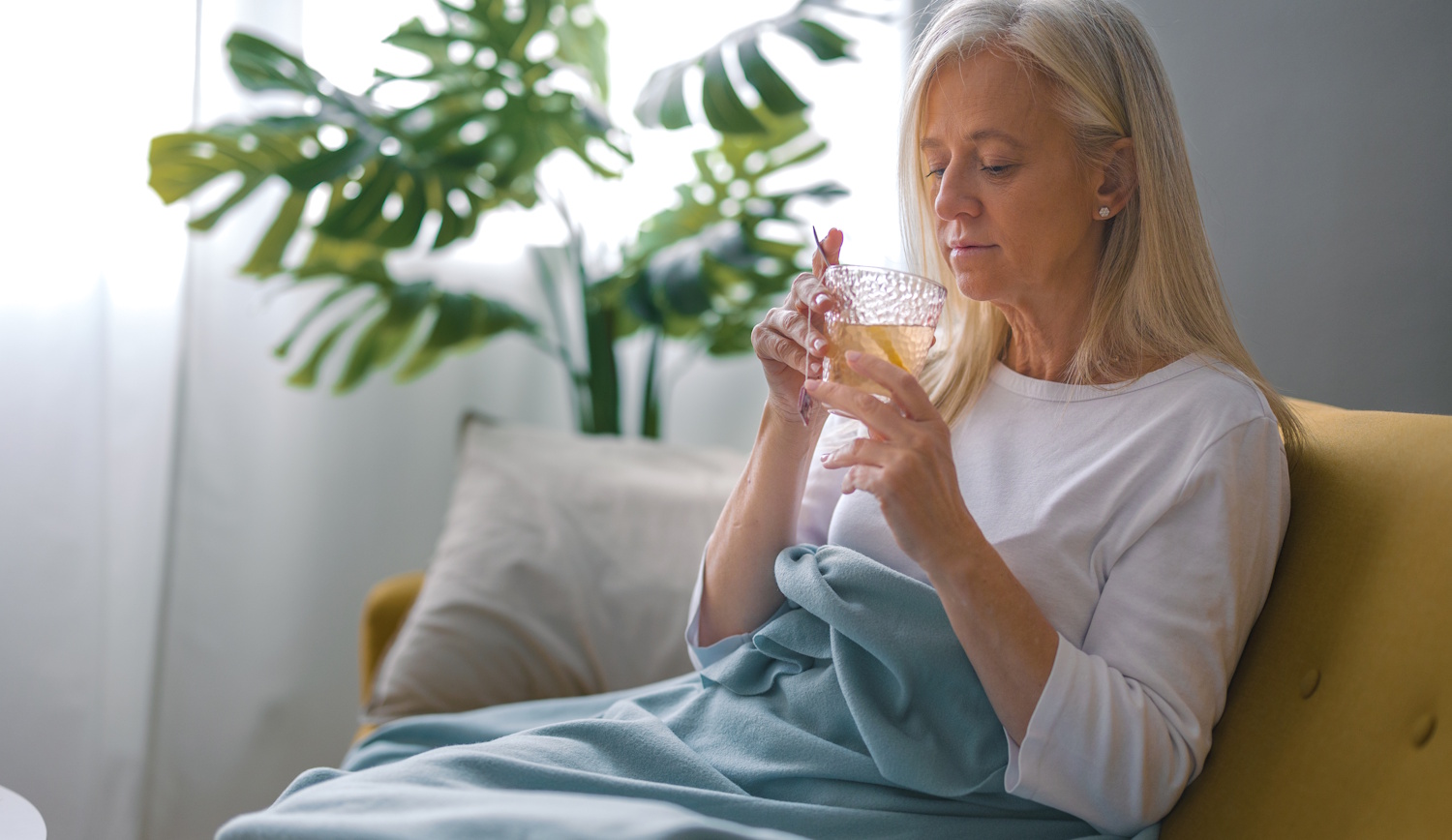 Egy nő iszik a kanapén