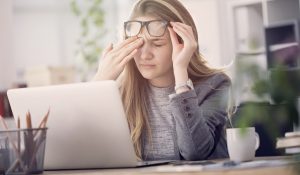 Egy nő stesszel a laptopja felett