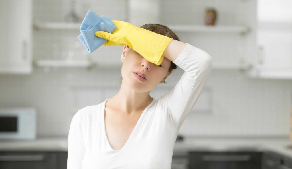 fáradt nő takarítás közben gumikesztyűben