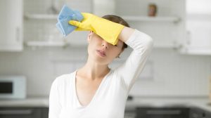 fáradt nő takarítás közben gumikesztyűben