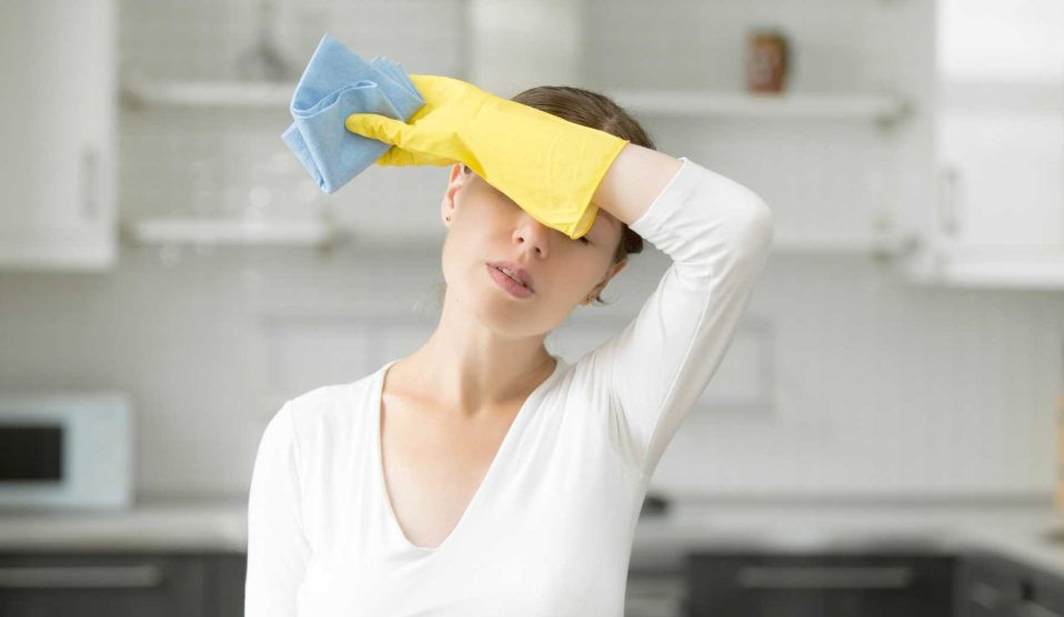 fáradt nő takarítás közben gumikesztyűben