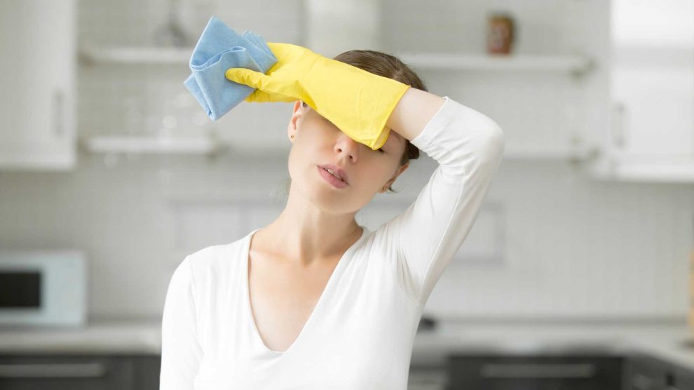 fáradt nő takarítás közben gumikesztyűben