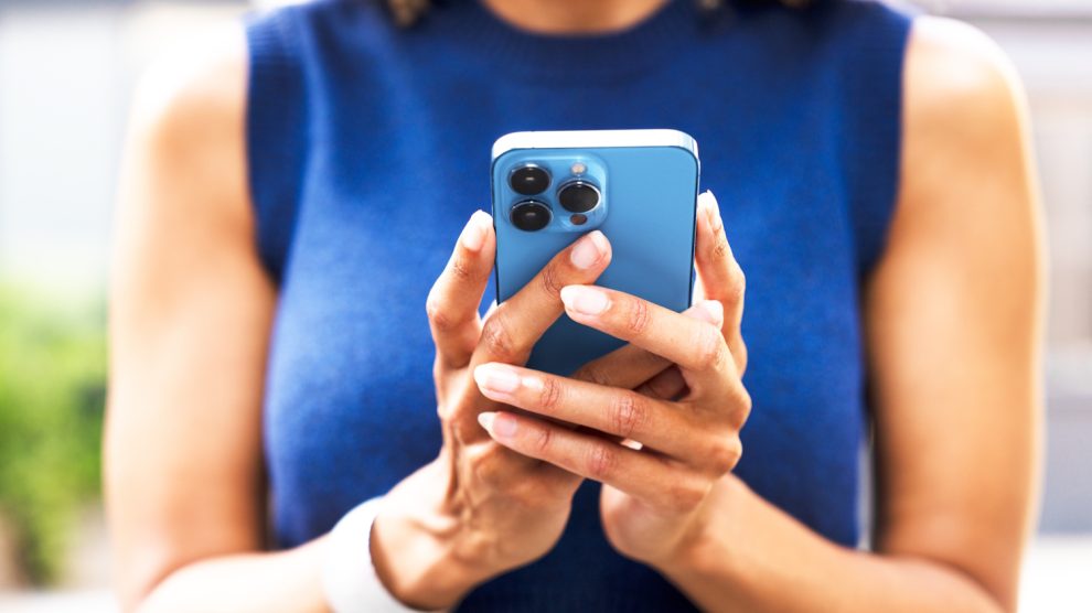 Egy lány nyomkodja a telefonját