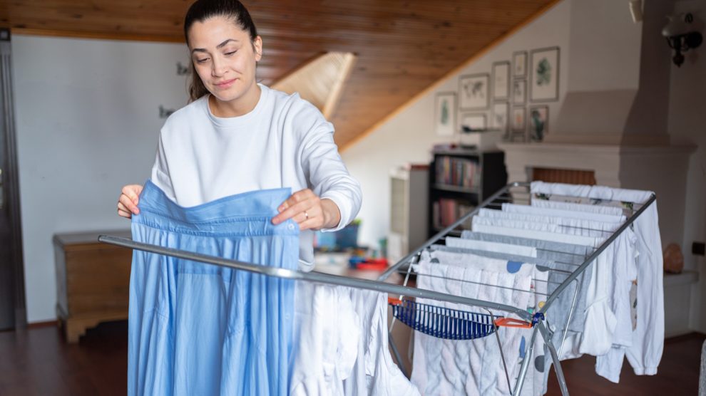 nő ruhákat tereget télen a lakásban
