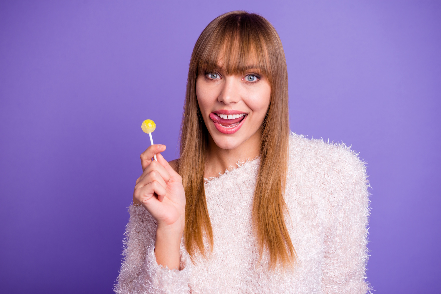 Egy nő nyalókával a kezében mosolyog