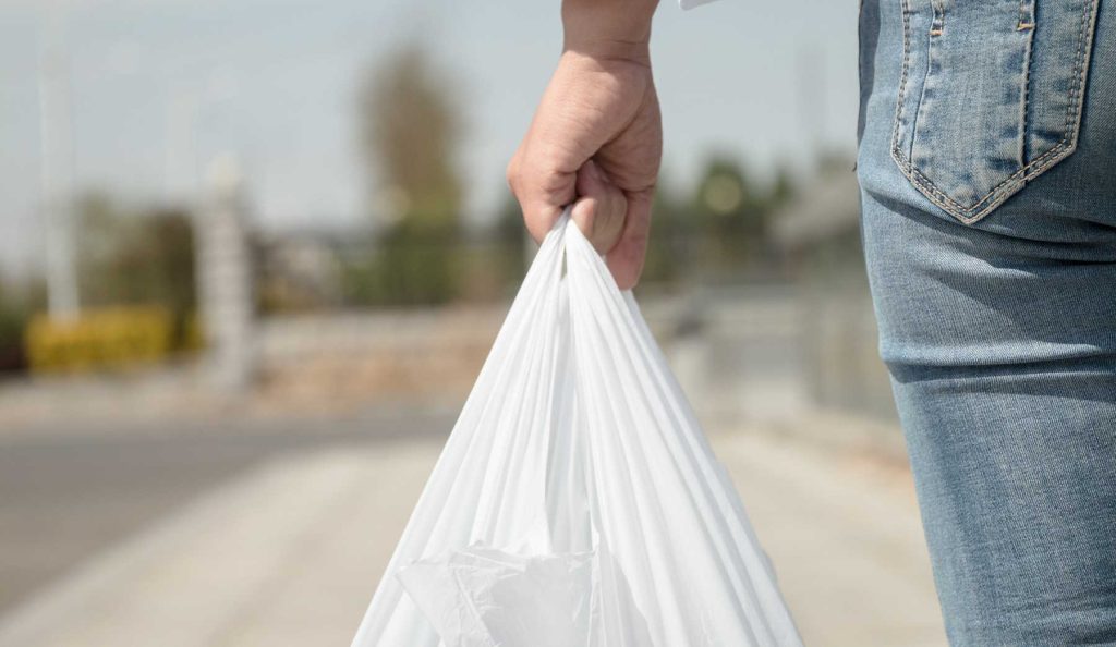 nő fehér zacskóval sétál