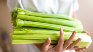 EGy nő zellert tart a kezében