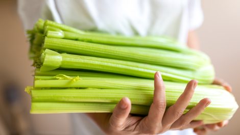 EGy nő zellert tart a kezében