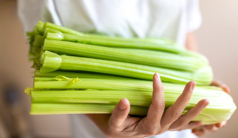 EGy nő zellert tart a kezében