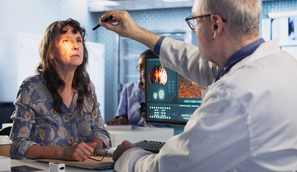 Egy orvos tollfénnyel vizsgál egy nőt az orvosi rendelőben