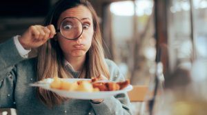 Egy nő vizsgálja az ételt nagyítóval