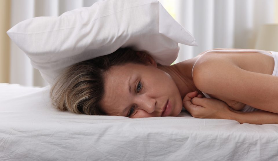 Párnával a fején egy álmatlan nő