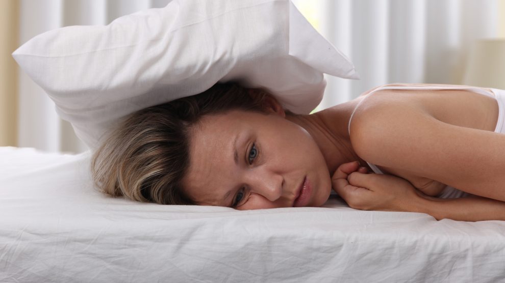 Párnával a fején egy álmatlan nő