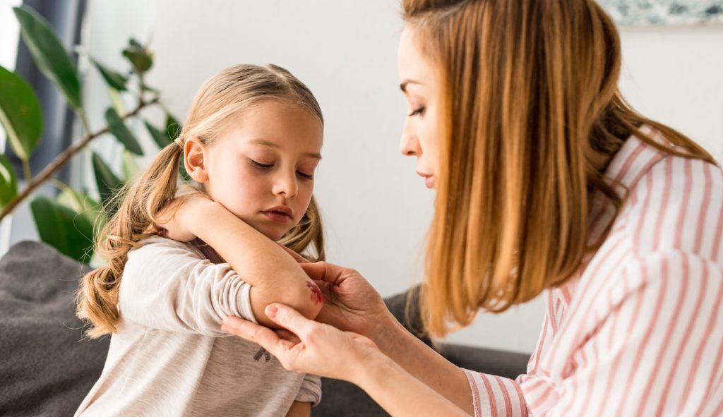 kislány horzsolását látja el az anyukája