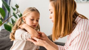 kislány horzsolását látja el az anyukája