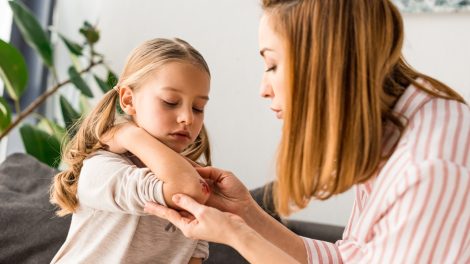 kislány horzsolását látja el az anyukája