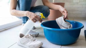 nő ecetes oldattal spricceli a fehér cipőjét