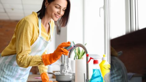 fiatal háziasszony a csaptelepet takarítja vízkő ellen