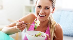 nő mosolyog salátával